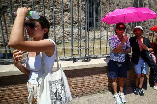 Một du khách che mặt khỏi ánh nắng mặt trời gần đấu trường La Mã ở Rome (Italy). Ảnh: Reuters.