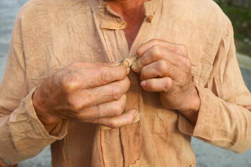 Trên áo truyền thống của người đàn ông Ơ Đu có 1 hàng khuy áo, nhưng không có cúc mà sử dụng các nút khóa để cài khi mặc áo. Ảnh: Xuân Tiến - TTXVN