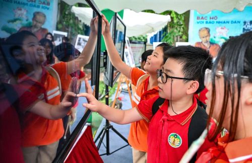 Các em học sinh hào hứng tiếp cận nội dung báo chí đa nền tảng của Báo Nhân Dân. (Ảnh: KIM ẢNH)
