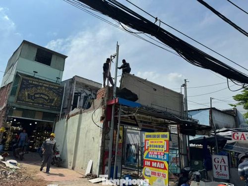 Công nhân đang tháo dỡ tường ngôi nhà để nhường đất mở rộng quốc lộ 13.