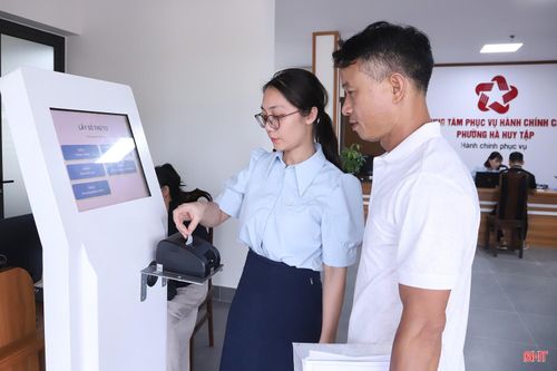 Cán bộ Trung tâm Phục vụ hành chính công phường Hà Huy Tập hỗ trợ người dân khi đến giao dịch.