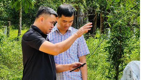 Anh Nguyễn Văn Trí (bên trái) với chiếc điện thoại thông minh trong tay có thể biết rõ vị trí đàn bò của gia đình.
