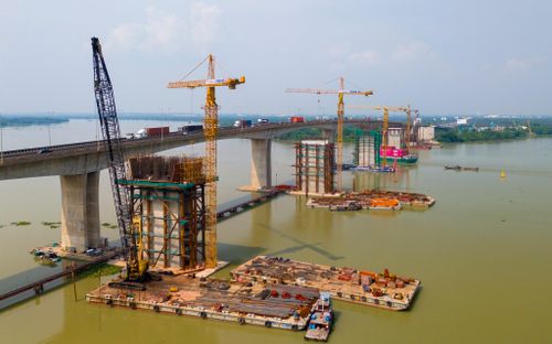 Sau hơn 10 tháng kể từ ngày khởi công, các trụ cầu đã vươn cao giữa sông Đồng Nai. Hiện nhà thầu đang huy động hàng trăm nhân sự cùng hơn 100 đầu xe máy, thiết bị, chia làm hàng chục mũi thi công, tổ chức hai ca làm việc liên tục trên bờ và giữa sông.