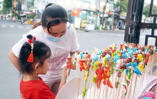 Các em nhỏ ngắm nhìn và lựa chọn những chiếc tò he ngộ nghĩnh. Ảnh: DANH THÀNH