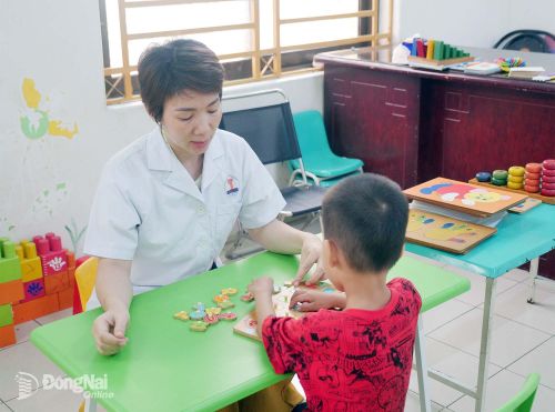 Cử nhân giáo dục đặc biệt Nguyễn Thị Tươi chăm sóc trẻ tự kỷ tại Bệnh viện Tâm thần Trung ương 2. Ảnh: Hạnh Dung