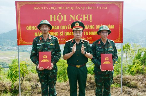 Thượng tá Phạm Khắc Trường - Chính trị viên Đội tìm kiếm, quy tập hài cốt liệt sĩ (ngoài cùng bên trái) nhận Quyết định thăng quân hàm ngay tại thực địa. (Ảnh: Lan Hương)
