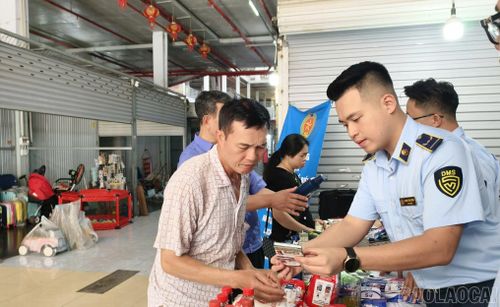 Cán bộ quản lý thị trường hướng dẫn người dân cách phân biệt hàng thật - hàng giả.