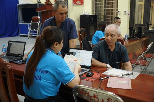 Ông Nguyễn Văn Dân ở thôn Trung Thượng được cán bộ tư pháp xã Ứng Hòa hỗ trợ làm lại giấy khai sinh. Ảnh: Hoàng Sơn