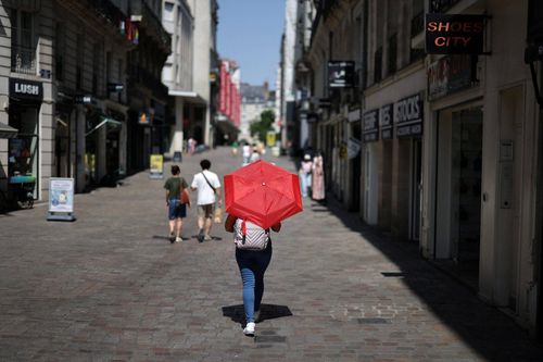  Một phụ nữ đi bộ trên đường phố Nantes trong lúc nhiệt độ tăng cao do đợt nắng nóng ảnh hưởng đến nhiều khu vực nước Pháp, ngày 22/6. Ảnh: Reuters. 