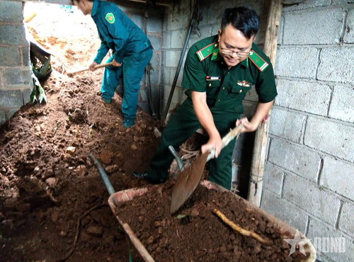 Cán bộ, chiến sĩ Đồn Biên phòng Cửa khẩu Săm Pun và lực lượng Ban CHQS xã Sơn Vĩ hỗ trợ người dân khắc phục hậu quả sạt lở đất. 