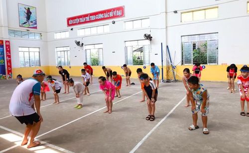 Thầy Đỗ Văn Thiệu hướng dẫn các em khởi động trước khi bơi.