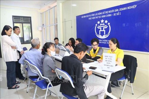 Người dân xã Minh Châu được cán bộ, tình nguyện viên tư vấn, hướng dẫn và thực hiện thủ tục hành chính tại điểm phục vụ theo Mô hình “Dịch vụ công lưu động”. Ảnh: Vũ Quang/TTXVN
