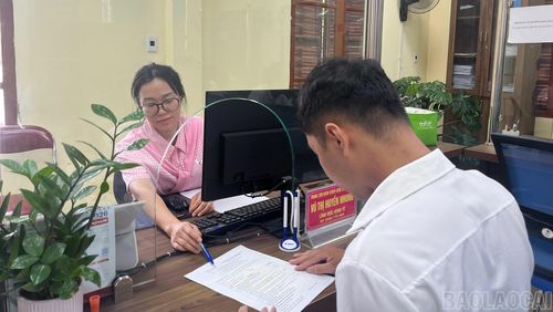 Chị Vũ Thị Huyền Nhung hướng dẫn người dân điền thông tin trong hồ sơ giải quyết thủ tục hành chính.