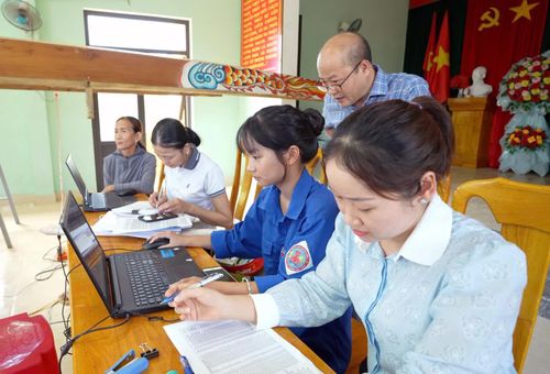 Cán bộ xã Lệ Ninh hỗ trợ người dân đối chiếu, số hóa hồ sơ đất đai - Ảnh: L.C