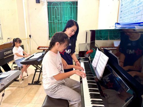 Giáo viên tận tình hướng dẫn học sinh luyện tập những bài học đầu tiên tại lớp piano.