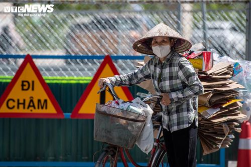 Khoảng 15h, tại khu vực đường Tố Hữu, bà Trần Thị Lan (54 tuổi) vẫn cặm cụi tìm kiếm các loại phế liệu trong những điểm tập kết rác ven đường. Dù thời tiết nắng gắt, người phụ nữ lớn tuổi vẫn nhanh tay nhặt từng chai nhựa, giấy vụn và túi nilon có thể bán lại. “Những ngày này đi lại rất mệt vì trời quá nóng. Nhưng đây cũng là thời điểm lượng rác tập kết nhiều hơn nên tôi tranh thủ kiếm thêm chút tiền từ đồ đồng nát”, bà Lan chia sẻ.