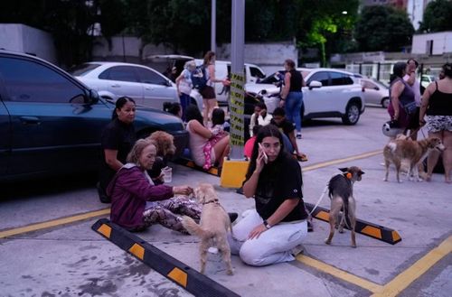 Người dân ngồi ngoài phố ở Caracas sau khi động đất xảy ra. Ảnh: Ariana Cubillos/ AP.