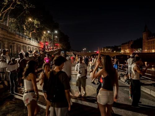 Những người trẻ tập trung bên bờ sông Seine ở Paris lúc 1h48 ngày 25/6. Ảnh: Rafael Yaghobzadeh/Le Monde.