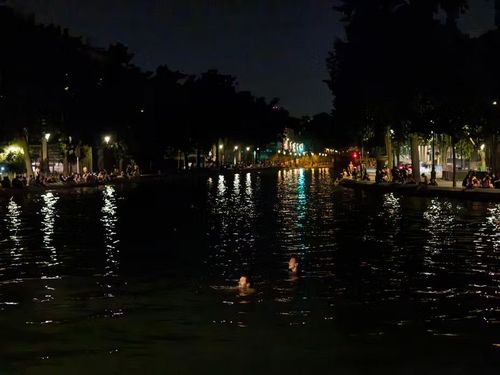 Nhiều người trẻ vẫn bơi tại kênh đào Saint-Martin ở Paris, lúc 0h47 ngày 25/6. Ảnh: Rafael Yaghobzadeh/Le Monde.