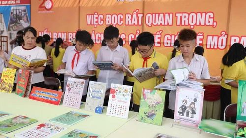 Các em học sinh đọc sách tại gian trưng bày tại sự kiện.