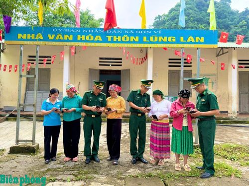 Cán bộ, chiến sĩ Đồn Biên phòng Sơn Vĩ hướng dẫn nhân dân quét mã QR trên điện thoại thông minh. Ảnh: Kim Khánh