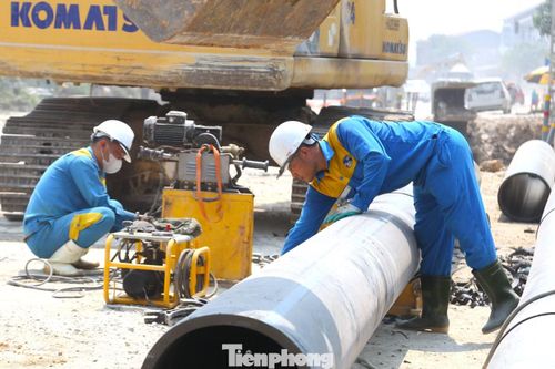 Công nhân nhà máy nước Nghệ An đội nắng lắp đặt hệ thống thoát nước tại dự án cải tạo Quốc lộ 46 đoạn Vinh - Nam Đàn.