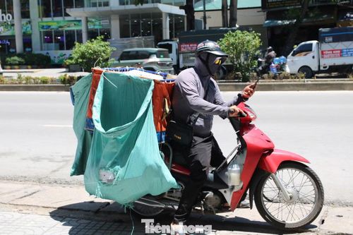 Giữa cái nắng gắt, người giao hàng vẫn tất bật di chuyển trên các tuyến phố để kịp giao đơn cho khách.