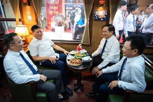  Thứ trưởng Y tế Đỗ Xuân Tuyên và Giám đốc Bệnh viện Bạch Mai Đào Xuân Cơ bên trong toa hành khách hướng về Phủ Lý. Toa tàu được thiết kế cụm ghế 4 người đối xứng kèm bàn trà, tạo sự thoải mái cho đoàn công tác và các chuyên gia trao đổi công việc dọc đường. 