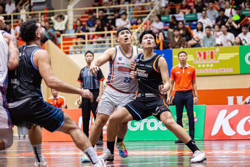 Đinh Toàn Quốc (áo đen) tranh vị trí lấy bóng với cầu thủ Hanoi Buffaloes.