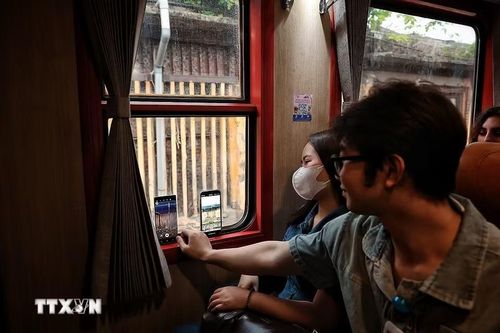 Các cán bộ, nhân viên y tế Bệnh viện Bạch Mai tranh thủ ghi lại khoảnh khắc đoàn tàu đi qua khuôn viên Bệnh viện Bạch Mai cơ sở 1. (Ảnh: Phạm Tuấn Anh/TTXVN)