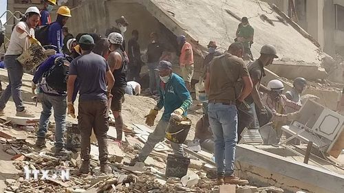 Các lực lượng cứu hộ Venezuela tìm kiếm những người mất tích và mắc kẹt dưới đống đổ nát. (Ảnh: Phi Hùng/TTXVN)