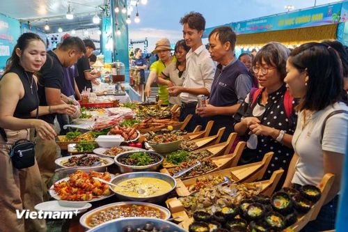 Không gian ẩm thực tấp nập người dân và du khách đến thưởng thức các món hải sản tươi ngon đặc trưng của vùng biển Quảng Phú. (Ảnh: Thanh Phong/Vietnam+)