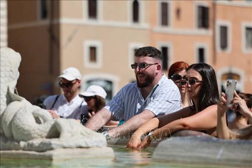 Người dân làm mát bên đài phun nước ở Rome, Italy. Ảnh: THX/TTXVN