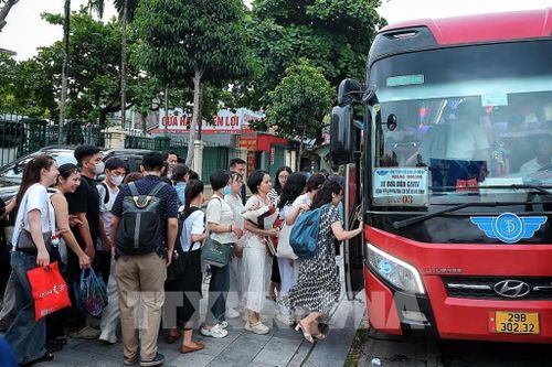 Các cán bộ, nhân viên y tế Bệnh viện Bạch Mai di chuyển lên xe trung chuyển để tới Bệnh viện Bạch Mai cơ sở 2. Ảnh: Phạm Tuấn Anh - TTXVN 