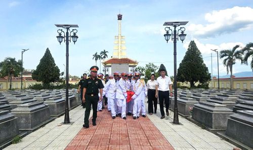 Lực lượng chức năng di chuyển hài cốt liệt sĩ đến nơi an táng. Ảnh: LAM PHƯƠNG