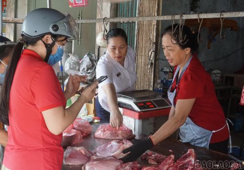 Cán bộ Trung tâm Dịch vụ tổng hợp xã Yên Bình trao đổi cùng các tiểu thương về công tác đảm bảo an toàn vệ sinh thực phẩm.