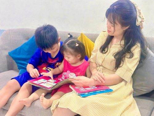 Chị Hương cùng 2 con chăm chú đọc sách