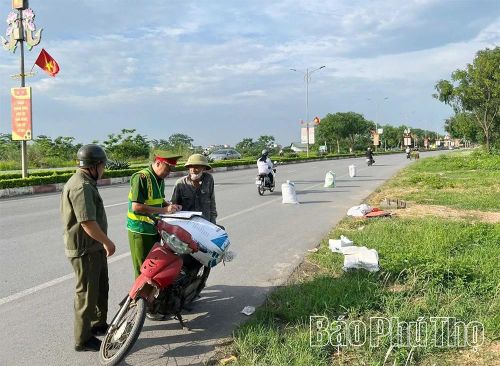 Công an xã Yên Lạc tuyên truyền, hướng dẫn người dân ký cam kết không phơi nông sản trên đường giao thông.