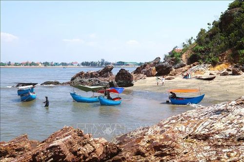 Nhiều chiếc thuyền nhỏ gắn động cơ chở khách du lịch neo đậu tại khu vực bãi tắm trước cửa hang Mũi Trâu.