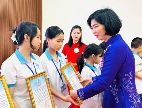 Phó Bí thư Thành ủy, Chủ tịch HĐND thành phố, Phó Trưởng đoàn đại biểu Quốc hội thành phố Hà Nội Phùng Thị Hồng Hà trao quà tới các em được đỡ đầu. Ảnh: Bảo Lâm