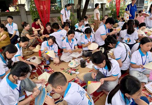 Các thiếu nhi trải nghiệm làm nón lá. Ảnh: Bảo Lâm