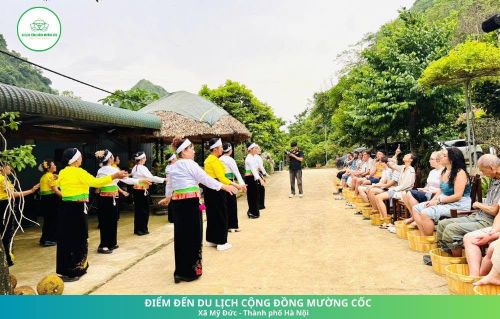 Khách quốc tế trải nghiệm hoạt động ngâm chân và thưởng thức văn hóa Mường tại khu du lịch Mường Cốc. Ảnh: M.C