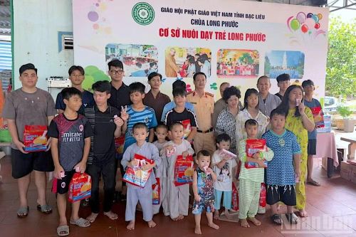 Cán bộ Phòng Cảnh sát giao thông Công an tỉnh Cà Mau trao quà cho các em nhỏ mồ côi, có hoàn cảnh đặc biệt khó khăn tại Cơ sở nuôi dạy trẻ Long Phước, tỉnh Cà Mau.