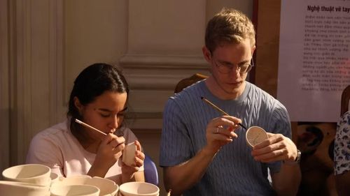 Du khách quốc tế trải nghiệm vẽ và trang trí trên gốm Lái Thiêu. Ảnh: Ngọc Anh.