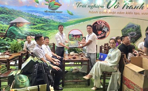  Lãnh đạo xã Vô Tranh tặng trà cho du khách đến thưởng thức tại gian hàng trưng bày.
