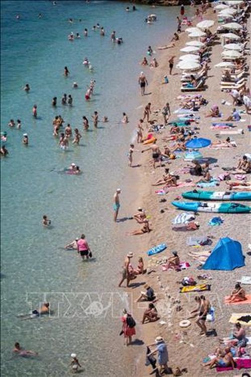 Người dân làm mát tại bãi biển ở Dubrovnik, Croatia. Ảnh: THX/TTXVN