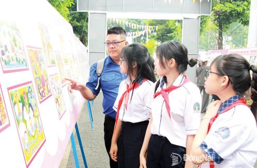 Giáo viên Tổng phụ trách Đội và đội viên, thiếu nhi đến từ Trường THCS Trưng Vương (phường Xuân Lộc) tham quan triển lãm tranh trong khuôn viên Nhà Văn hóa thanh thiếu nhi thành phố.