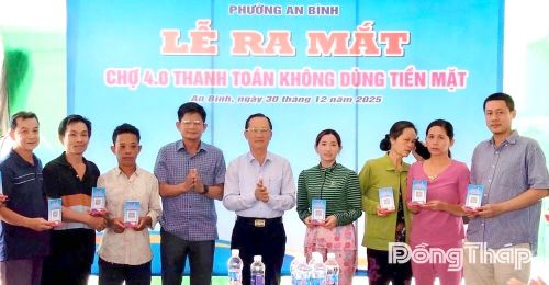 Lãnh đạo phường An Bình tặng bảng mã QR cho các hộ tiểu thương tại Lễ ra mắt mô hình Chợ 4.0 thanh toán không dùng tiền mặt. Ảnh: DƯƠNG ÚT - QUỐC TÍN
