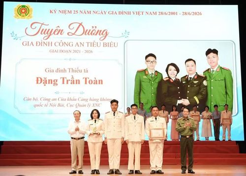 Gia đình Thiếu tá Đặng Trần Toàn (Cục Quản lý xuất nhập cảnh) tại Lễ tuyên dương gia đình Công an tiêu biểu giai đoạn 2021-2026. Ảnh: ĐVCC