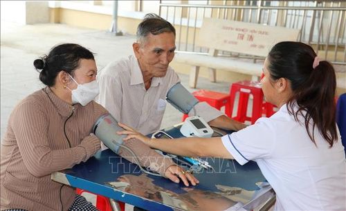 Nhân viên y tế kiểm tra sức khỏe của người dân đến khám sàng lọc bệnh tại tỉnh Đồng Tháp. Ảnh: Hữu Chí/TTXVN